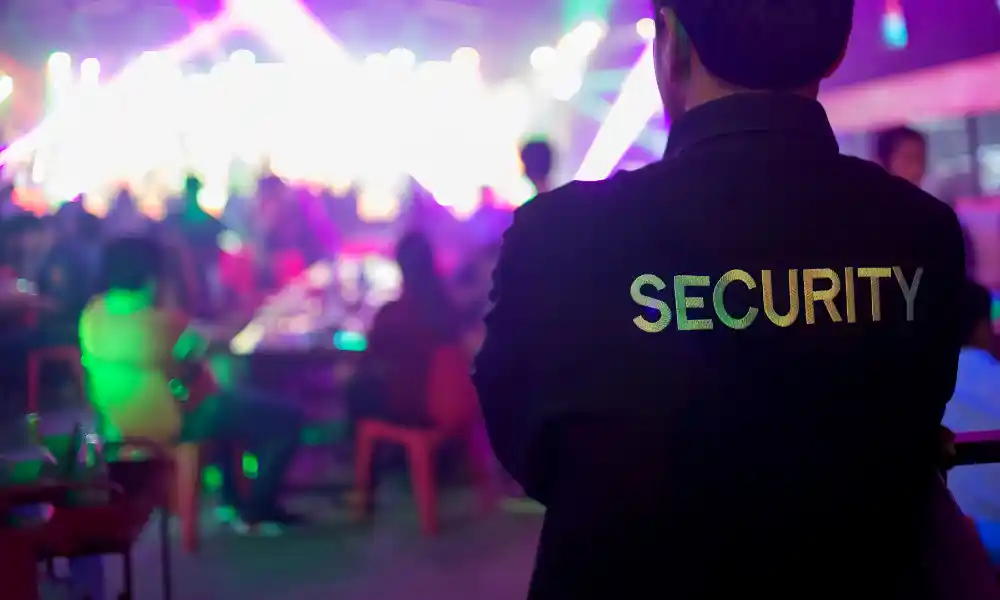 Event security guard monitoring crowd at night in Massachusetts